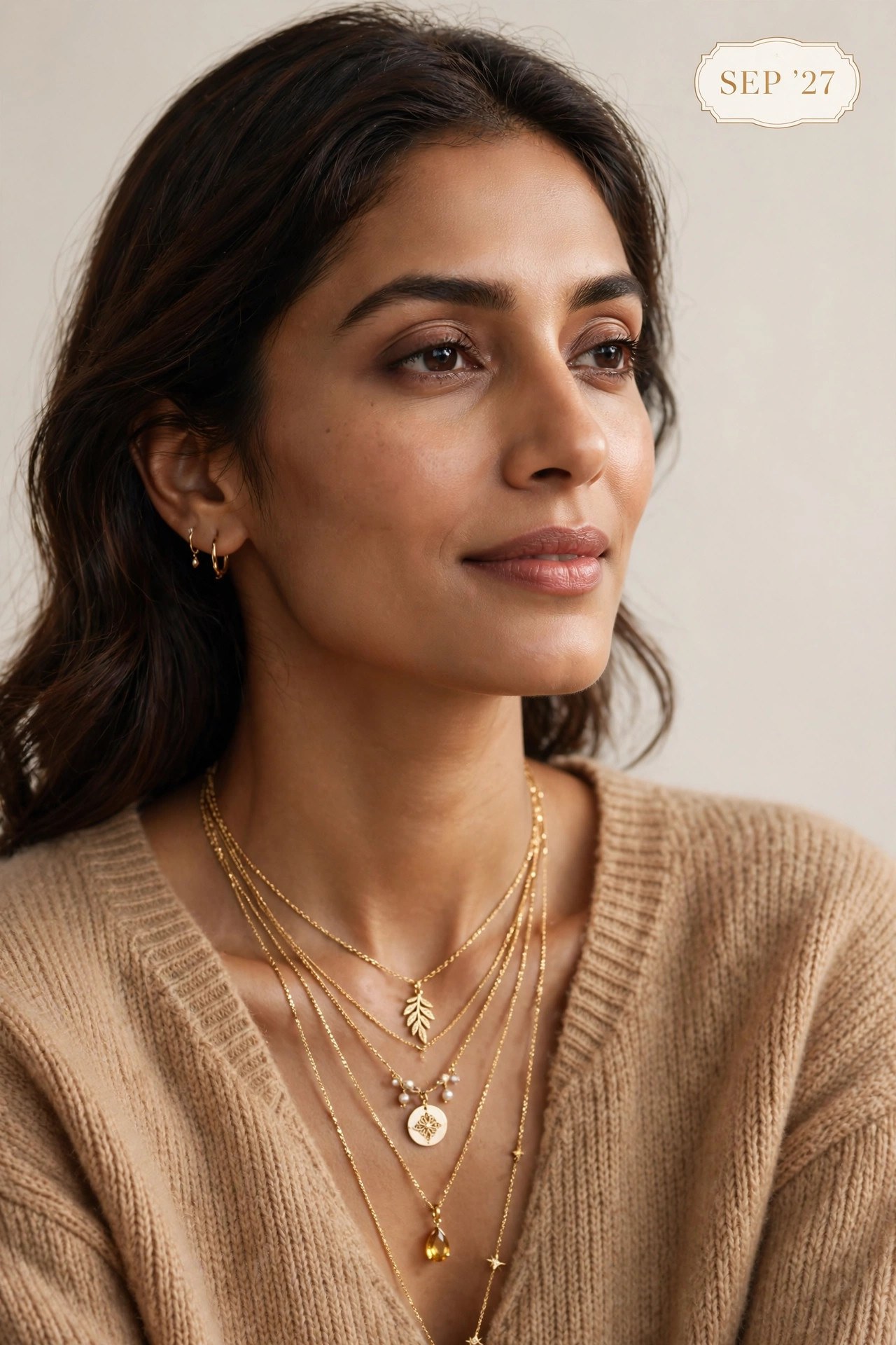 The Swag World Calendar 2027 September Spread - Model wearing layered delicate gold chains with medallion and citrine pendant