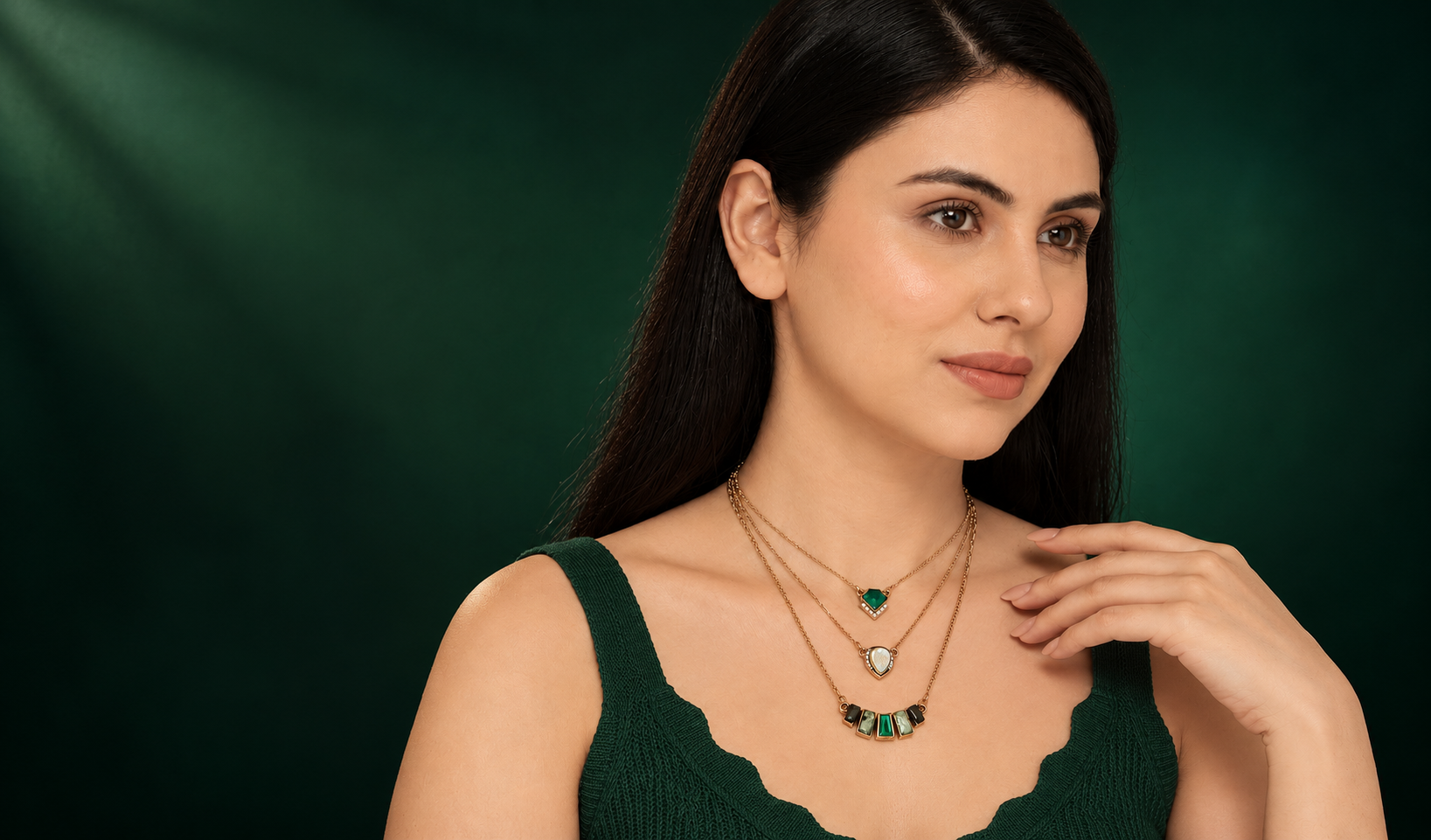 Model showcasing layered emerald and gold statement necklaces - The Swag World
