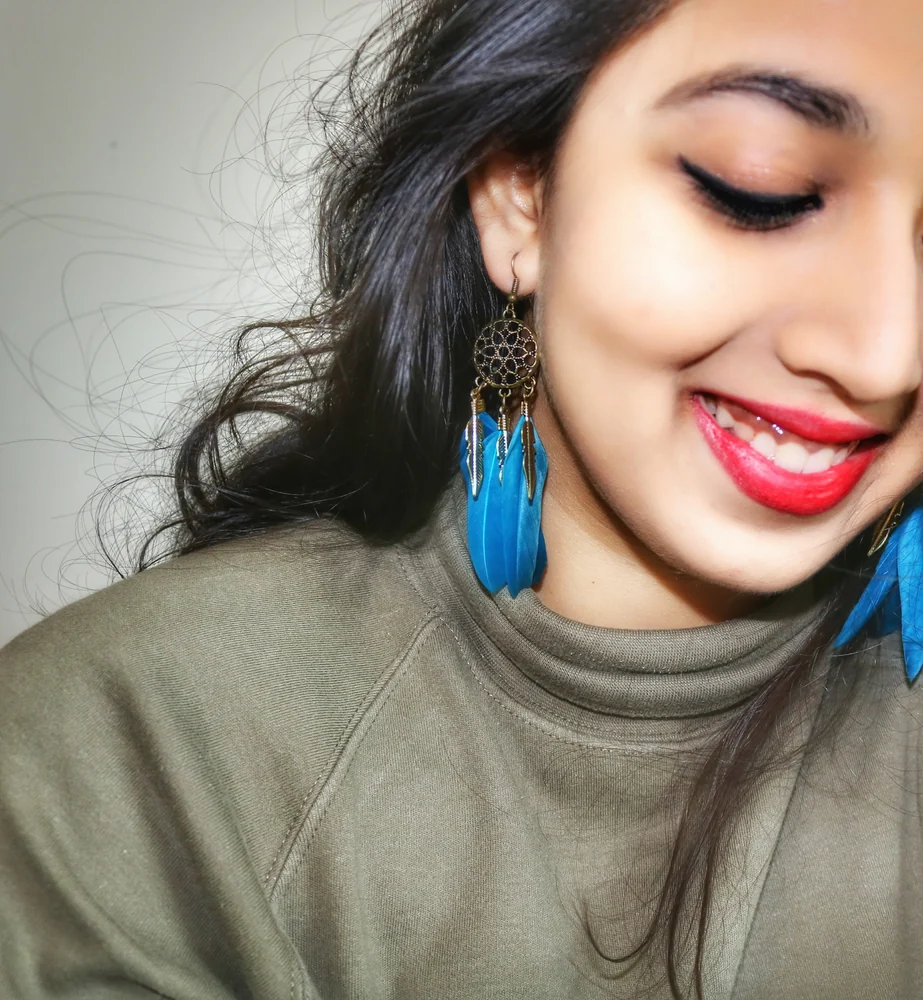 Real customer styling featuring teal feather statement earrings